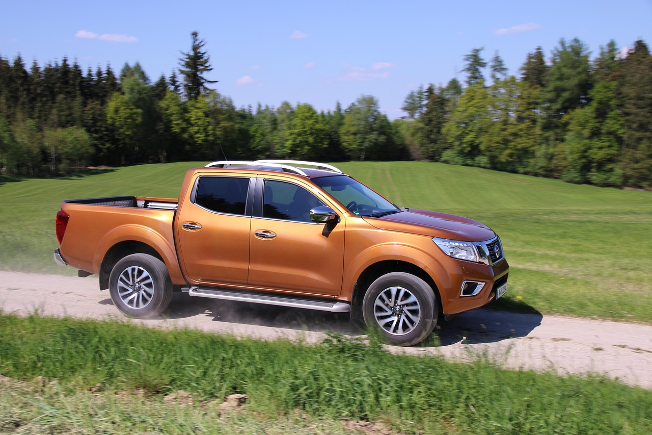 Orange pickup truck parked on a gravel drive