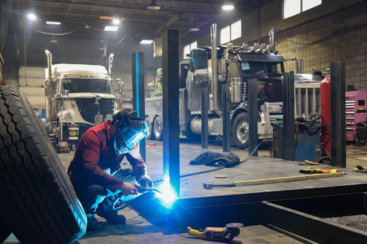 Truck shop with a mechanic working between vehicles